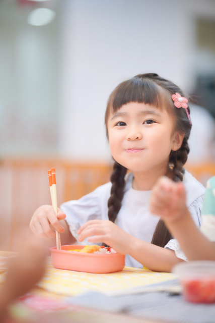 アンパンマンピックが入ったお弁当を食べる女の子